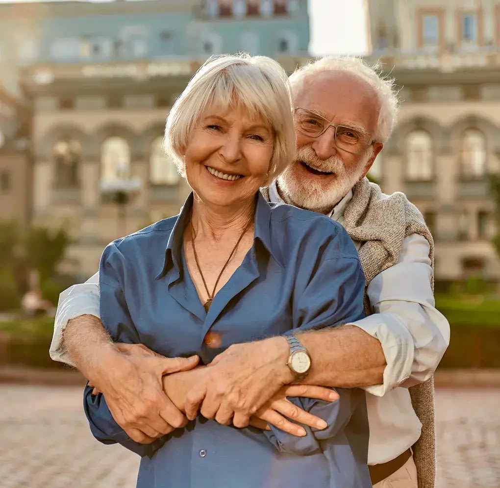 Happy elderly couple hugging outdoors