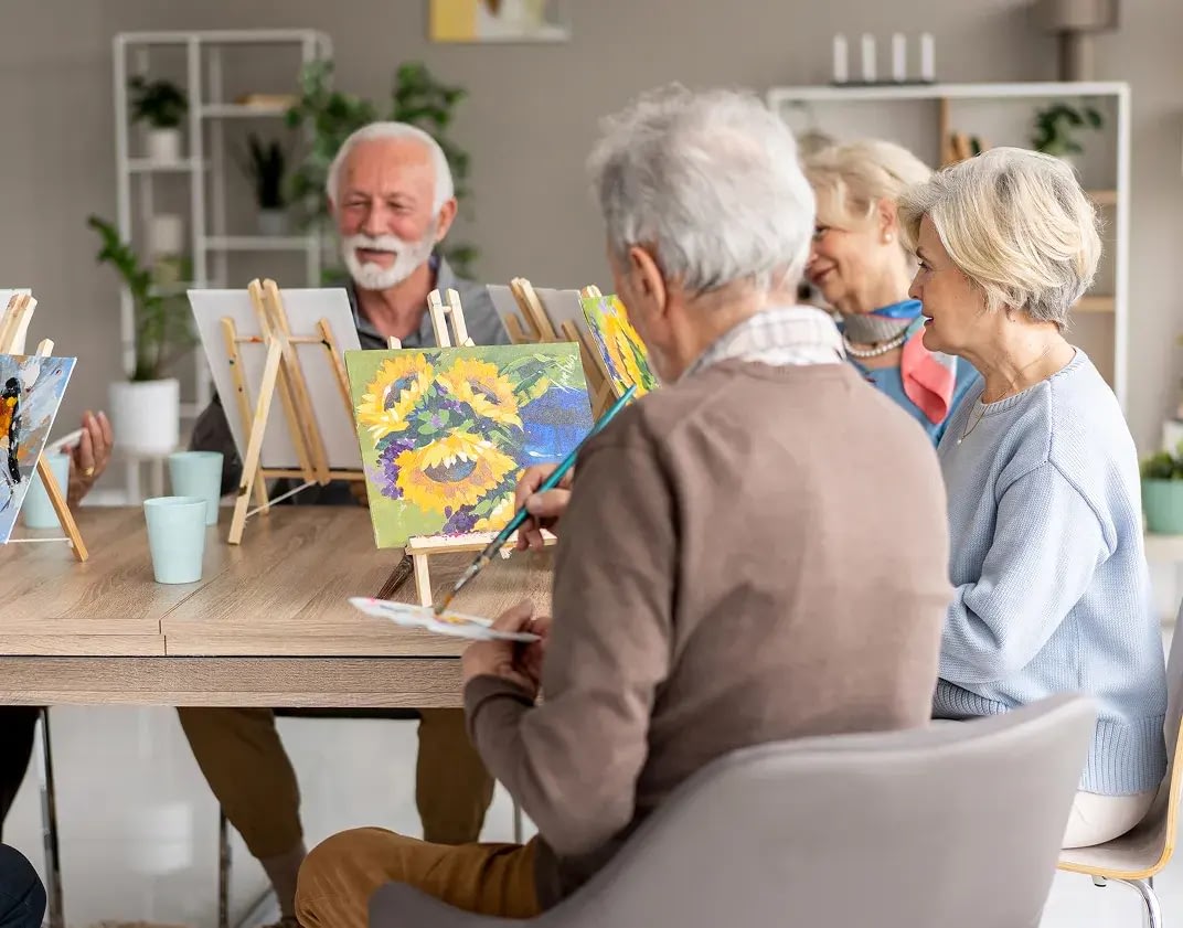 Seniors enjoying group painting class together