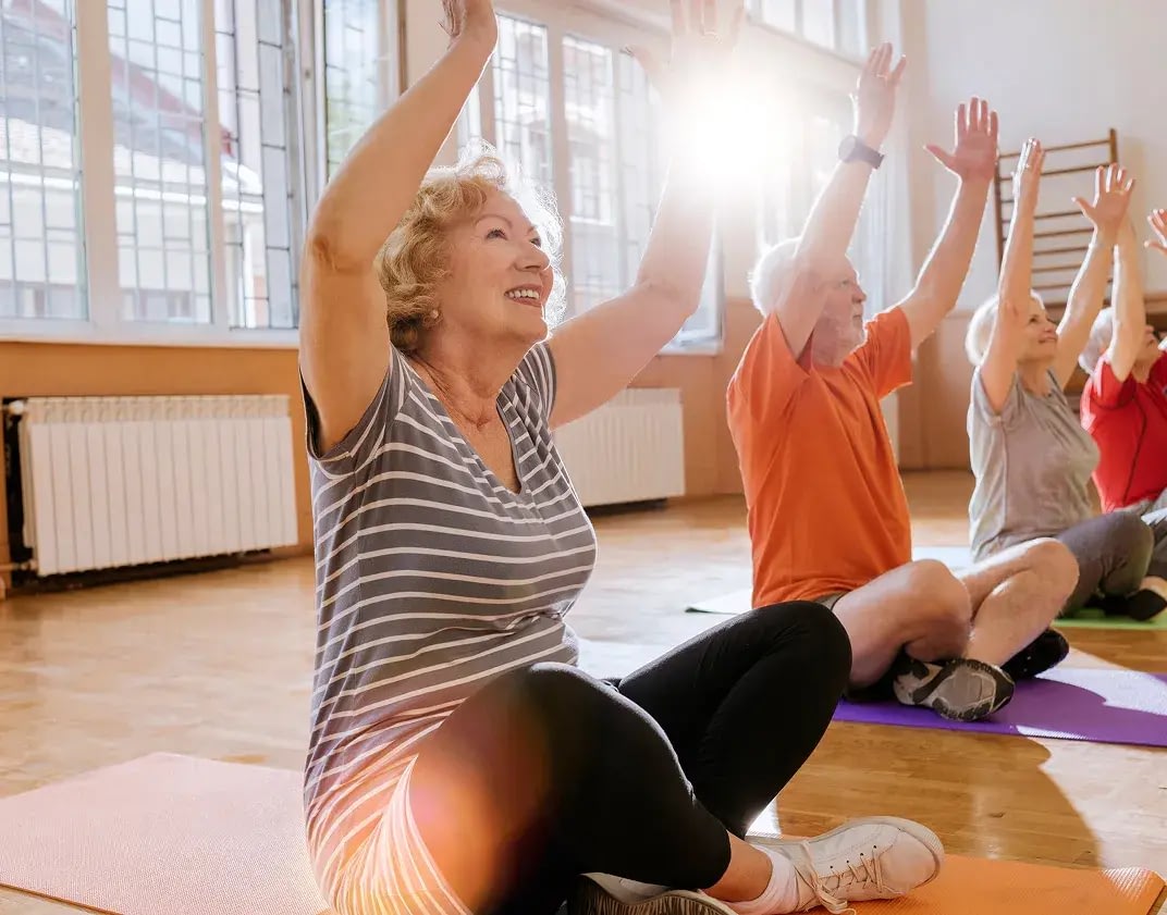 Senior group exercising indoors on yoga mats