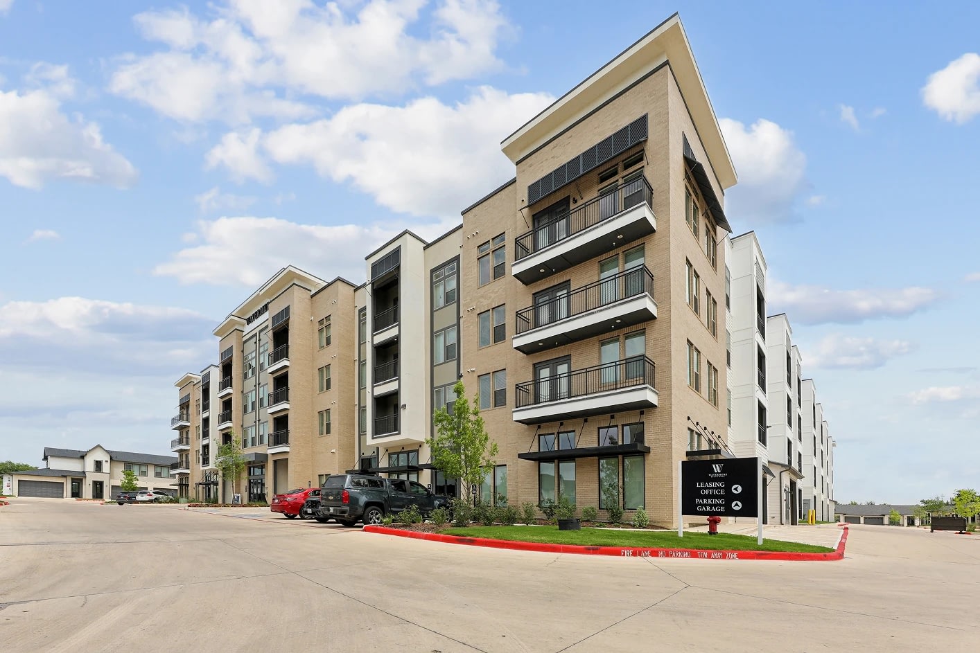 Modern apartment building with balconies and parking area