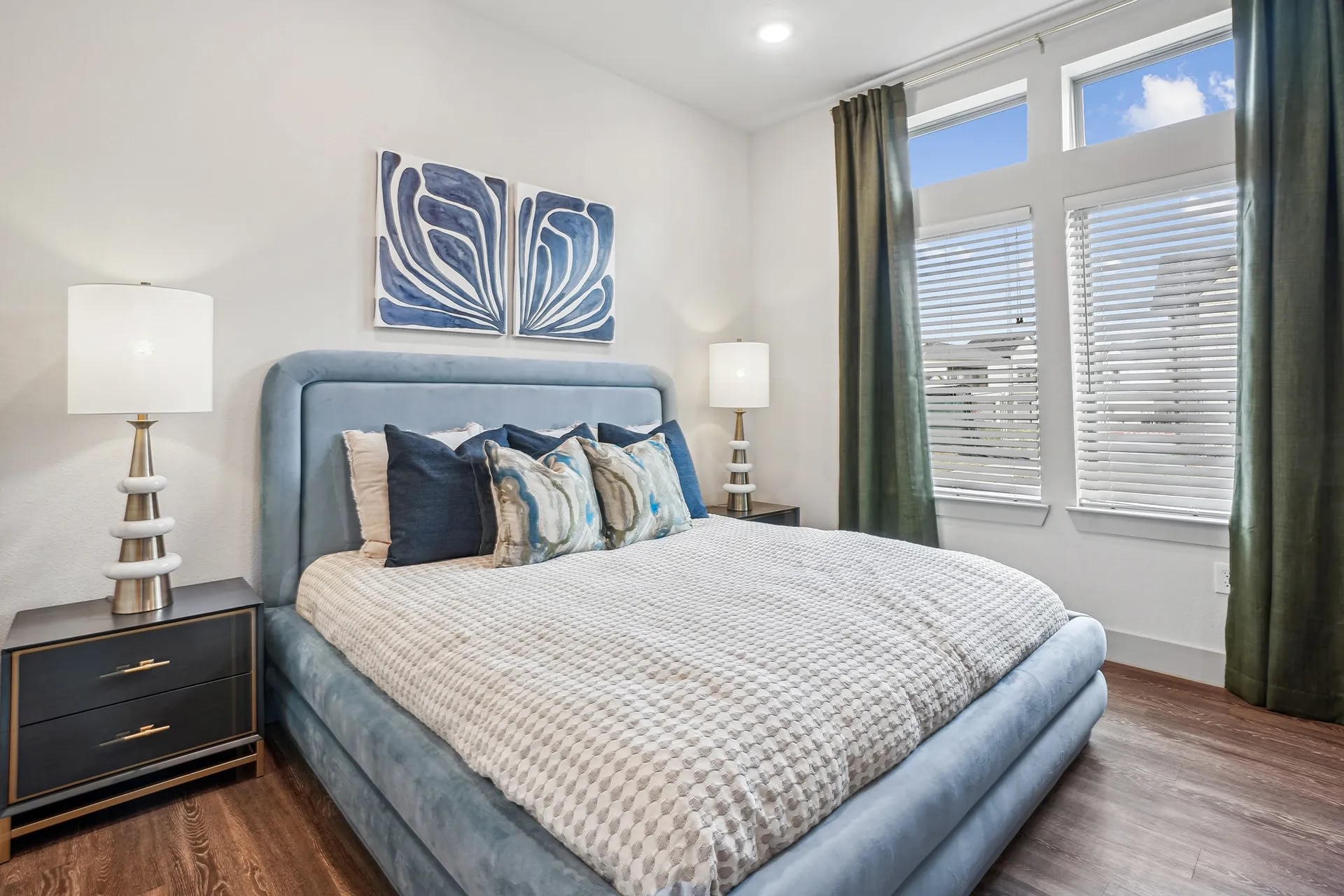 Bedroom with a large window, cozy bedding, and modern furnishings.