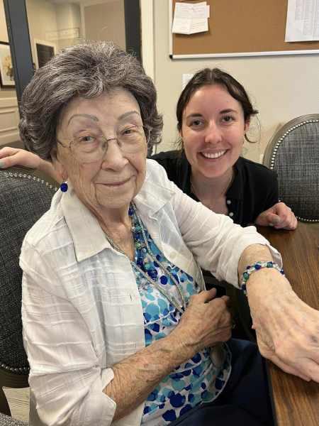 Smiling elderly woman sitting with younger woman indoors