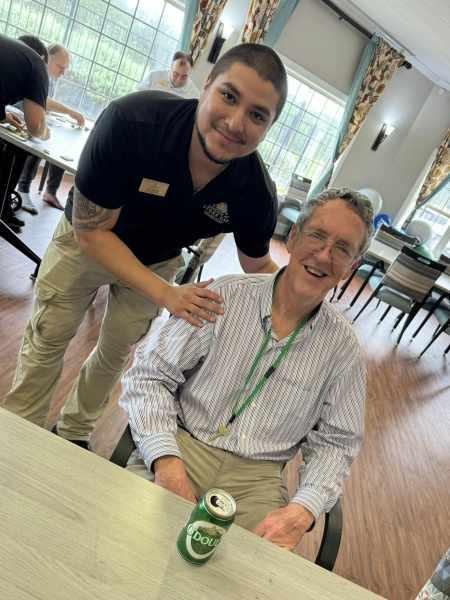 Staff member interacting with a male resident at a table