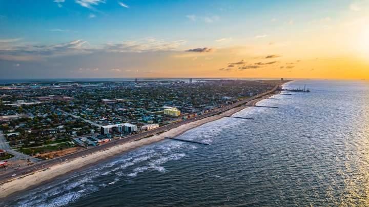 Aerial view of Galveston beach and coastline at sunset with waves and sandy shore