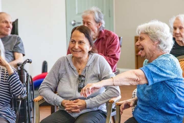 Group of seniors sitting and engaging in social activity together indoors