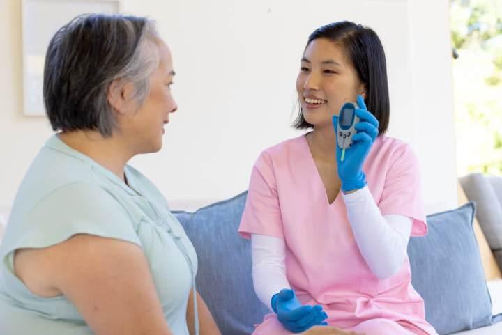 Nurse showing medical device to patient at home