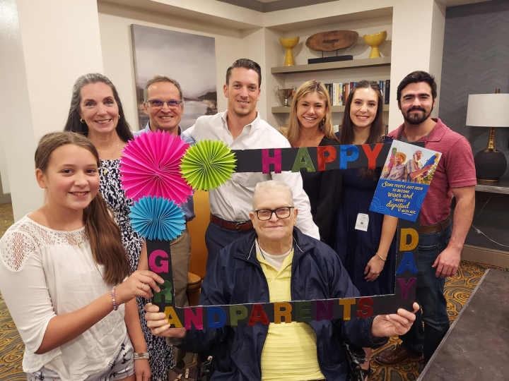 Multi-generational family celebrating with colorful decorations and Happy Birthday signs